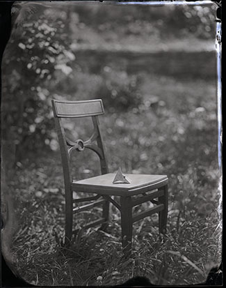 small photo: cardboard 3-dimensional figure on the seat of a chair